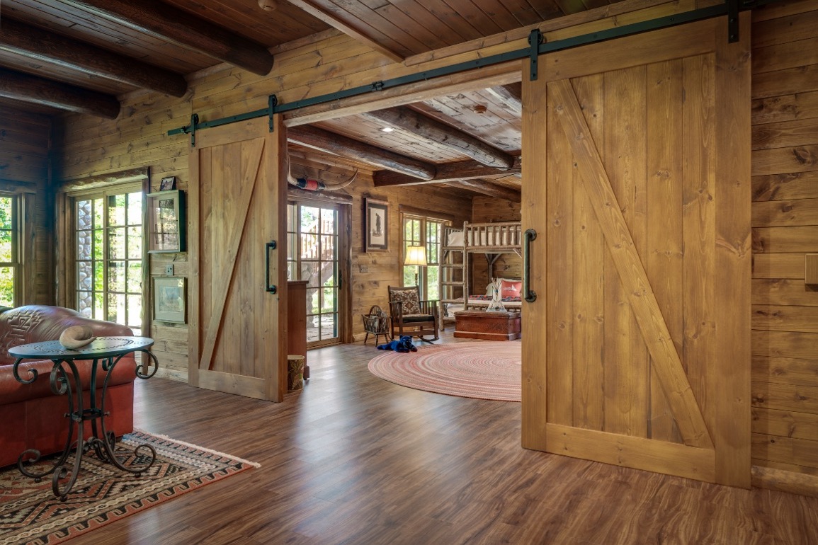 Barn door separating a main living room from a family room