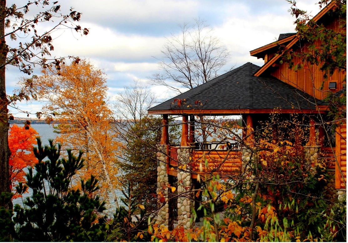 Log home overlooking a lake with fall trees in view