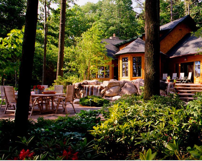 Logo home with a patio in a forest setting